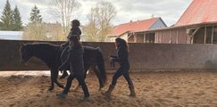 Auszubildende auf Pferd Auszubildende sitzen auf einem Pferd